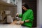 Happy, woman pours hot tea from teapot in the kitchen