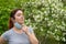 Happy woman pulls down a mask outdoors. A joyful girl walks in the park alone and takes off a medical mask. Social