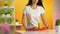 Happy woman putting tray with salad and fresh orange juice on table, snack bar