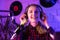Happy woman radio host with headphones broadcasting in studio