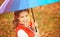 Happy woman with rainbow multicolored umbrella under rain in par