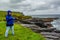 Happy woman on a rainy day at the coast with limestone rocks along the coastal walk route from Doolin to the Cliffs of Moher