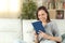 Happy woman reading a paper book sitting on a sofa