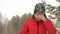 Happy woman in red clothes with snow on her face smiling after falling to snow at winter forest