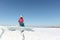 Happy woman in a red jacket sitting on an ice floe on a river