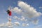 Happy woman on red T-shirt jumping to blue clound sky