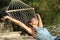 Happy woman relaxing on a hammock on holidays and raising arms