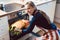 Happy woman removing pie from oven