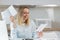 A happy woman is reviewing documents from the bank to close the loan, and received a positive bank account