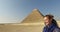 Happy woman riding horse in front of Giza pyramids