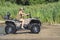 A happy woman riding a quad bike on the river.A girl on a Quad bike riding on the beach