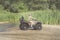 A happy woman riding a quad bike on the river.A girl on a Quad bike riding on the beach