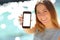 Happy woman showing a blank smartphone on the beach