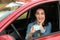 Happy woman showing driving license