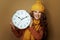 Happy woman showing round clock remind about autumn time change