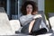 Happy woman sitting in the sun on indoor lounge