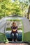 Happy woman sitting in tent holding tiny pumpkin