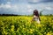 Happy woman sitting on yellow sunny flowers field