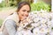 Happy woman smelling chamomile flowers in garden