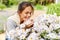 Happy woman smelling chamomile flowers in garden