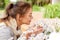 Happy woman smelling chamomile flowers in garden