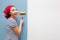 Happy woman smoothes air bubbles on the wallpaper with a roller. An experienced master applies various techniques to