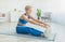 Happy Woman In Sportswear Stretching Legs On Floor Mat