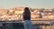 Happy woman standing on the balcony with view on the city Lisbon, Portugal.