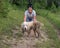 Happy woman standing with grimy dog in the woods.