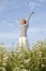 Happy woman with stretched arms in flower field