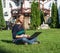 Happy woman student sitting on grass with laptop. Beautiful casual female outdoor using pc.