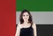 Happy woman student with thumb up on the UAE flag background. United Arab Emirates, travel and learn arabic language concept