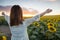 Happy woman in sunflower field. Summer girl in flower field cheerful. Asian Caucasian young woman raise arm OK and freedom show in