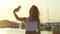 Happy woman taking mobile photo in evening port. Travel girl posing for selfie