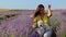Happy woman taking selfie with her Miniature Poodle dog in lavender field.