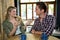 Happy woman talking with man at table in coffee shop