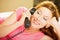 Happy woman talking on a phone lying in bed