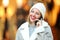 Happy woman talking on phone in winter in a mall