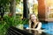 Happy woman talking on smartphone swimming at pool