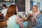 Happy woman talking to friend at cafe counter