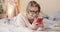 Happy woman text messaging using mobile phone in bed