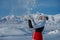 Happy woman throw snow on winter mountains background