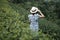 Happy woman tourist in blue dress and hat enjoy beautiful Tea garden.Traveler visiting in green natural hills in morning. travel,