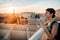 Happy woman tourist enjoying sunset cityscape panorama from Seville`s viewpoint.Amazed visitor having great experience traveling