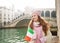 Happy woman tourist with Italian flag in front of Rialto Bridge