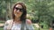 Happy woman tourist on vacation posing in front of waterfalls in tropical park