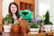 Happy woman transplanting potted flowers