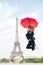 Happy woman travel in paris, france. Woman jump with fashion umbrella. Girl with beauty look at eiffel tower. Parisian