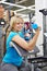 Happy woman tries dumbbell in sport shop