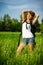 Happy woman turist in a summer field with backpack